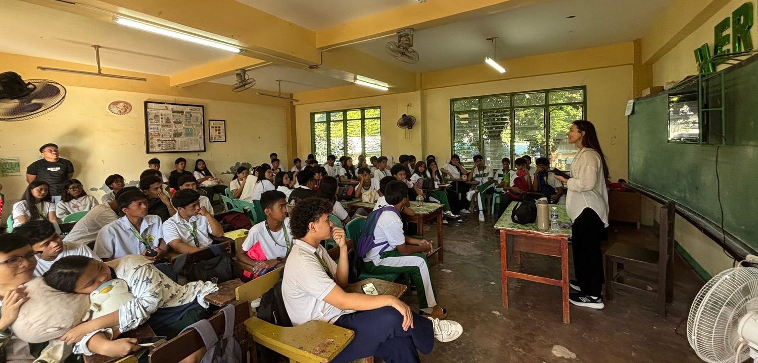 A hall of people kneeling and bowed in prayer during a mission outreach
